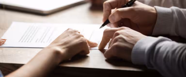 Person signing contract with guidance