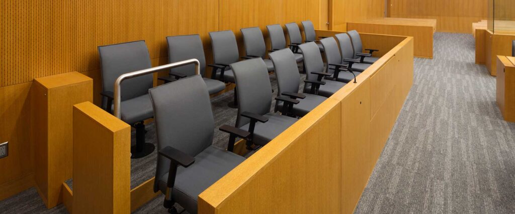 Empty chairs arranged in a courtroom representing the jury system in NSW