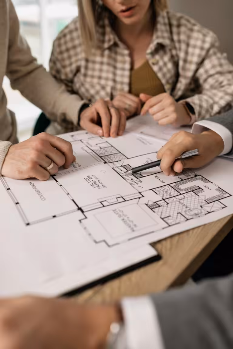People reviewing architectural house floor plan together