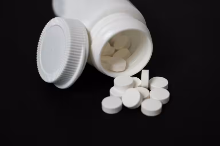 White tablets spilled from medicine bottle