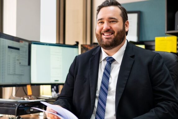 Smiling businessman working at office desk with documents