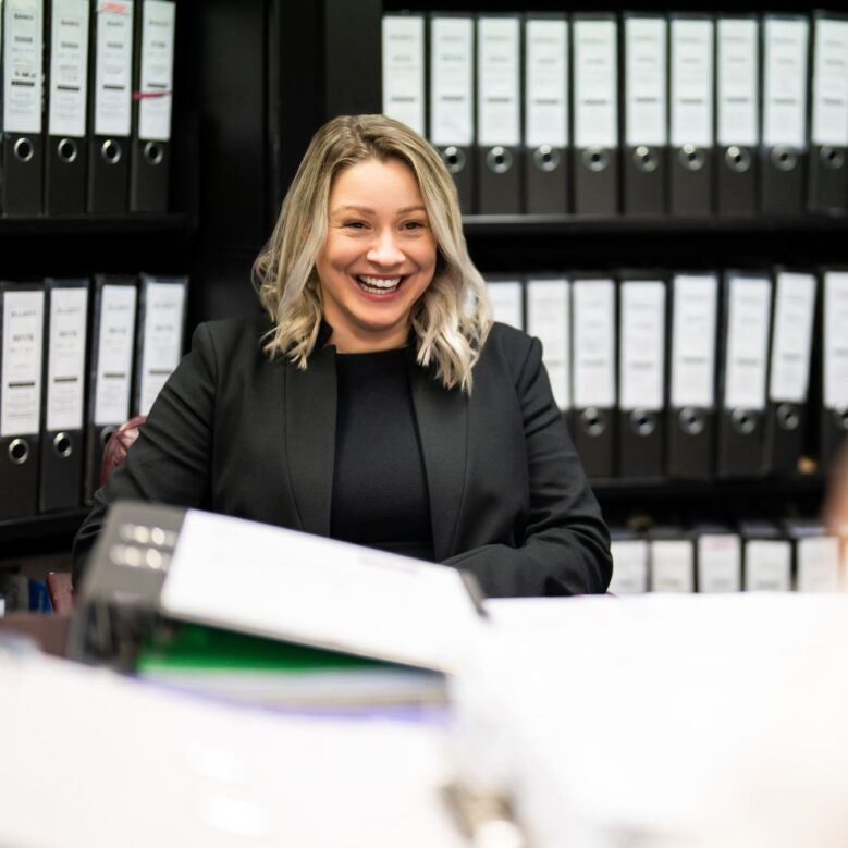 Smiling businesswoman in office with binders