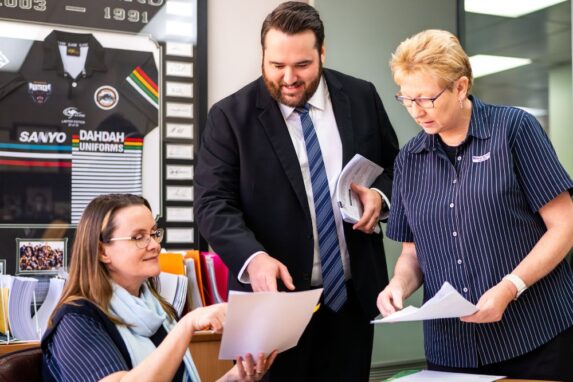 Colleagues discussing documents in office meeting