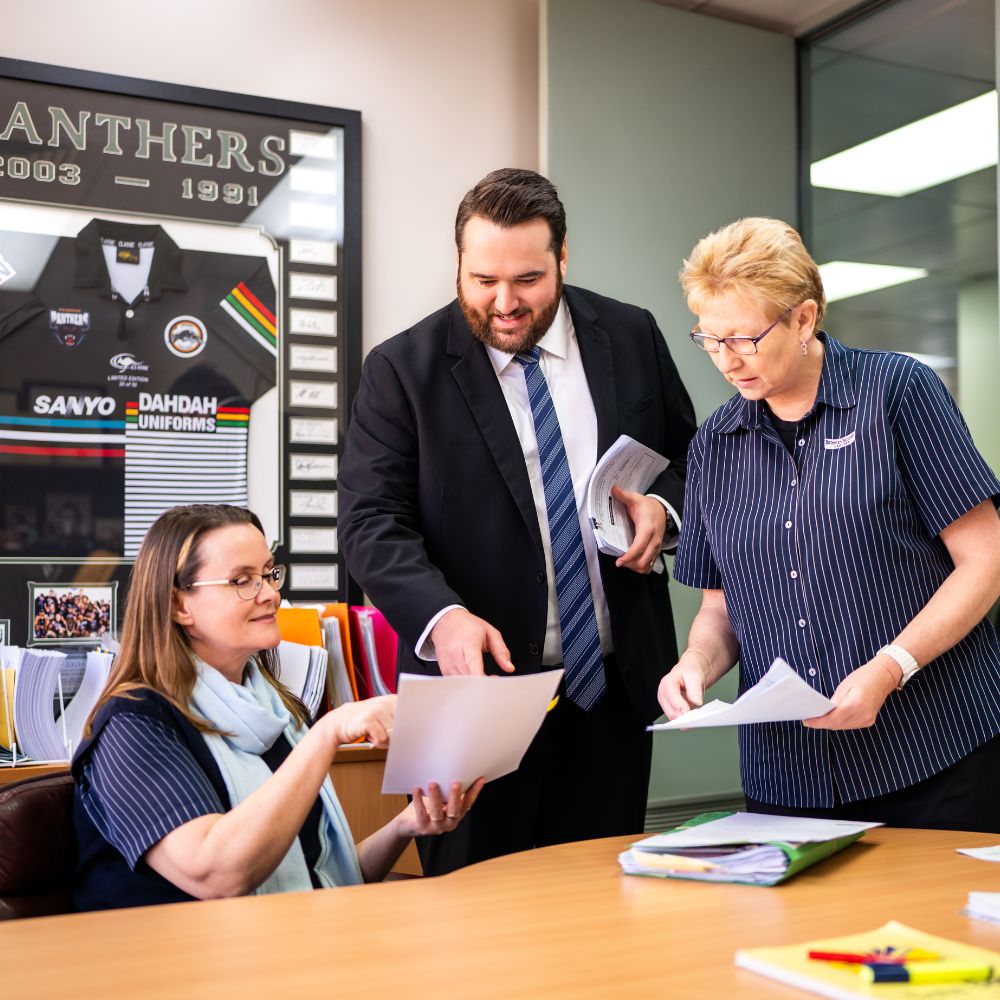 Colleagues discussing documents in office meeting