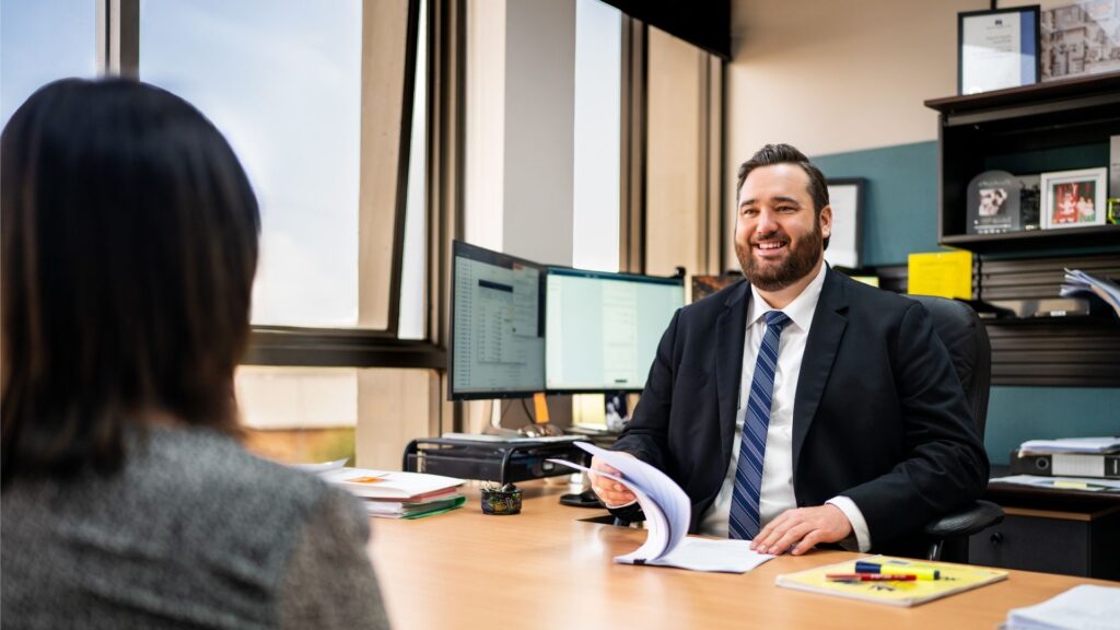 Smiling businessman interviewing woman in office