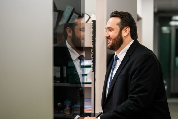 Smiling businessman in suit standing at office reception